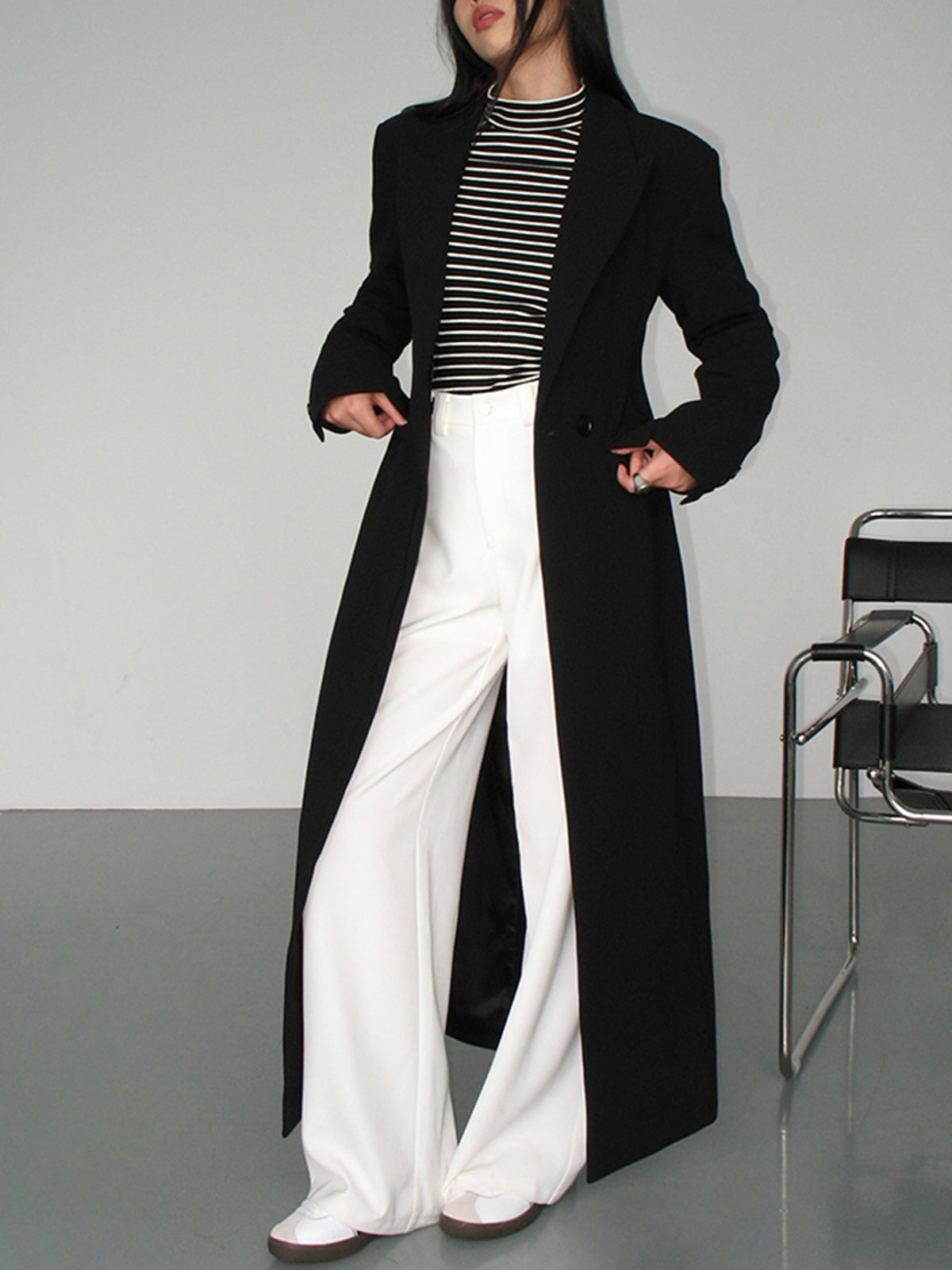 Langer-zweireihiger-mantel-in-schlichtem-design-mit-gestreiftem-shirt-und-weiter-hose-für-einen-modernen-und-entspannten-look