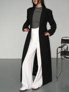 Langer-zweireihiger-mantel-in-schlichtem-design-mit-gestreiftem-shirt-und-weiter-hose-für-einen-modernen-und-entspannten-look