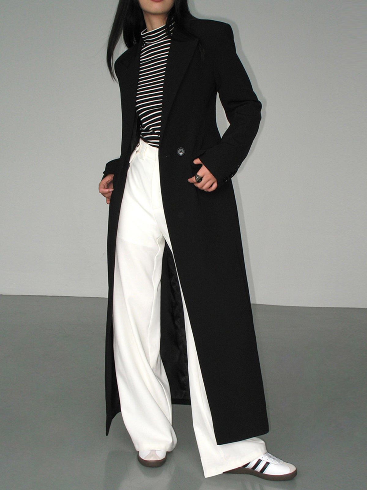 Langer-zweireihiger-mantel-in-schlichtem-design-mit-gestreiftem-shirt-und-weiter-hose-für-einen-modernen-und-entspannten-look