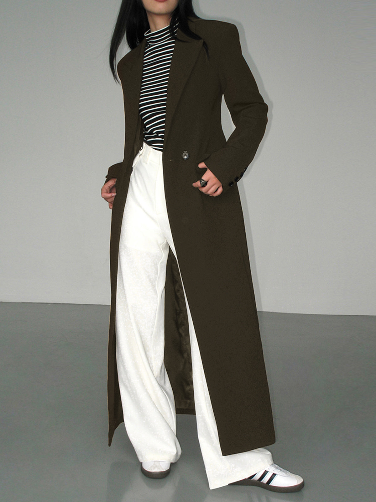 Langer-zweireihiger-mantel-in-schlichtem-design-mit-gestreiftem-shirt-und-weiter-hose-für-einen-modernen-und-entspannten-look
