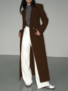 Langer-zweireihiger-mantel-in-schlichtem-design-mit-gestreiftem-shirt-und-weiter-hose-für-einen-modernen-und-entspannten-look