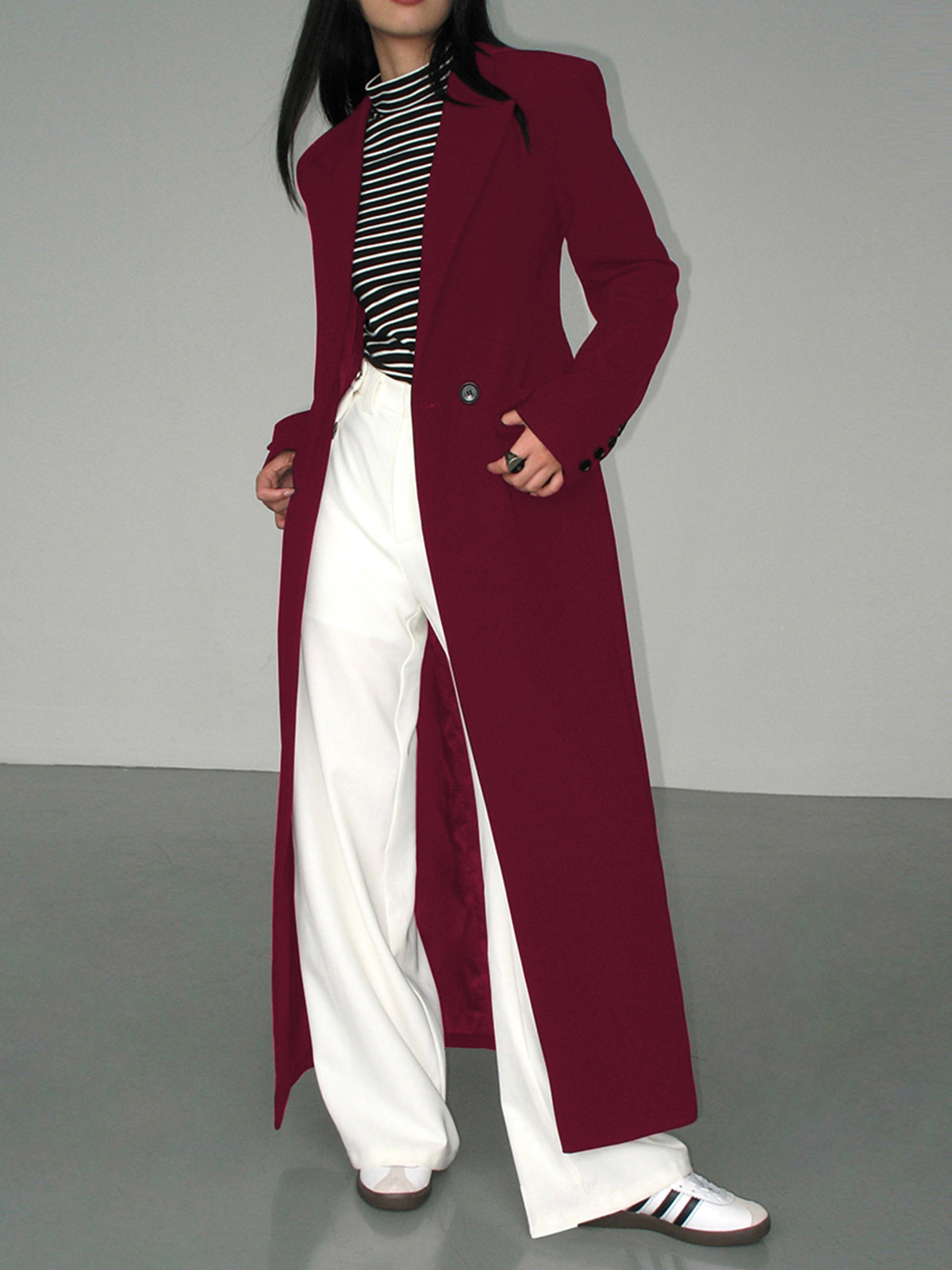 Langer-zweireihiger-mantel-in-schlichtem-design-mit-gestreiftem-shirt-und-weiter-hose-für-einen-modernen-und-entspannten-look