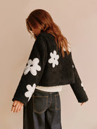 Blumenmuster–Fleecejacke–schwarz–mit–weißen–Blumen–Reißverschluss–bequem–und–lässig