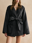 Ein eleganter, dunkler Wickelmantel mit Gürtelverschluss und großen aufgesetzten Taschen für einen stilvollen Look.