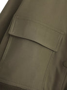 Militärstil–Khaki–Jacke–lässig–boxy-Passform–strukturiert–funktional–trendy.