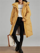 Ein-langer-Steppmantel-mit-Kapuze-und-großen-Taschen,-ideal-für-den-winterlichen-Stil-und-warme-Tage.