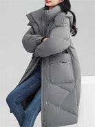 Ein-langer-Steppmantel-mit-Kapuze-und-großen-Taschen,-ideal-für-den-winterlichen-Stil-und-warme-Tage.