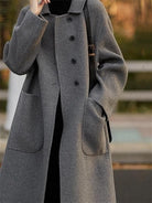 Ein-klassischer-Mantel-mit-einreihiger-Knöpfung-und-großen-Taschen,-ideal-für-einen-minimalistischen-und-eleganten-Look.