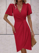 Wickelkleid-mit-kurzen-ärmeln-taillierter-passform-und-kurz-geschnittenem-vorderteil-für-einen-schlichten-und-femininen-look.
