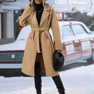 Ein-eleganter-langer-mantel-mit-taillengürtel-und-doppelt-geknöpftem-design,-ideal-für-einen-modischen-winterlichen-look.