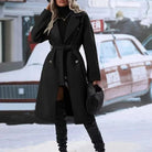 Ein-eleganter-langer-mantel-mit-taillengürtel-und-doppelt-geknöpftem-design,-ideal-für-einen-modischen-winterlichen-look.