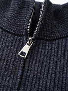 Ein-dunkelblauer-Pullover-mit-Reißverschluss-und-weißem-schneeflockenartigem-Muster.