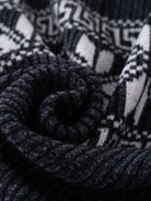 Ein-dunkelblauer-Pullover-mit-Reißverschluss-und-weißem-schneeflockenartigem-Muster.