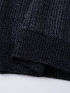 Ein-dunkelblauer-Pullover-mit-Reißverschluss-und-weißem-schneeflockenartigem-Muster.
