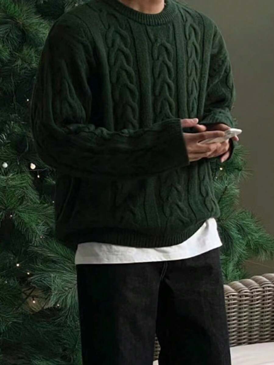 Ein-Mann-trägt-einen-dunkelgrünen-Strickpullover-mit-Zopfmuster,-perfekt-für-einen-warmen-und-stilvollen-Winterlook
