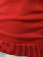 Ein-roter-und-blauer-Pullover-mit-weißen-Rentier-und-Tannenbaum-Mustern,-perfekt-für-festliche-Weihnachtsfeiern