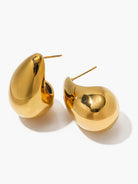 Ein-Paar-goldene-und-silberne-Tropfenförmige-Ohrstecker-auf-einem-Dekosteinelement.