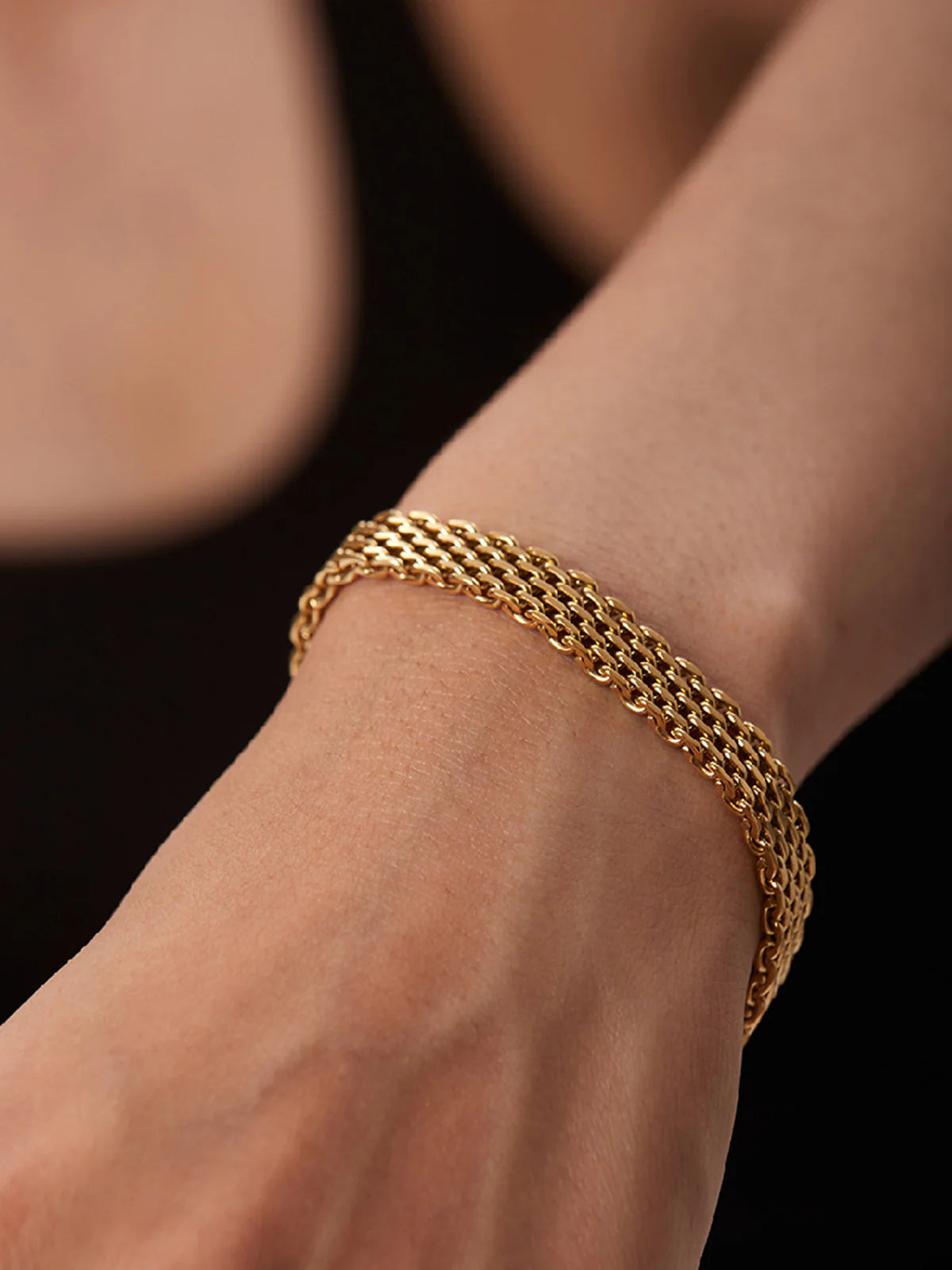 Ein-zeitloses-goldenes-Kettchen-Armband-am-Handgelenk-einer-Frau.